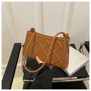 Detail of brown quilted rhombic shoulder bag with textured faux leather and knotted strap