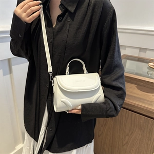 Elegant white crossbody handbag with minimalist wavy stitching and top handle