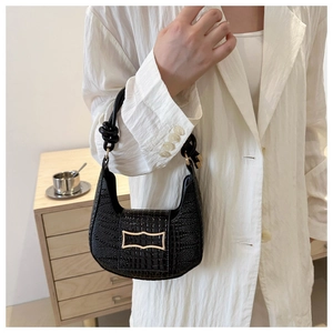 Detail of black crocodile texture hobo bag with gold buckle and knot handle