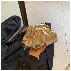 Gros plan d'un sac nuage doré métallisé montrant des plis et une texture détaillée