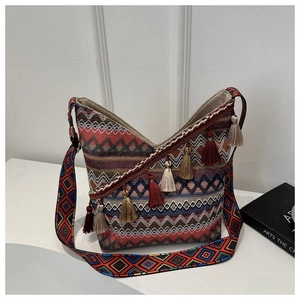 Macro-detail van geweven boho-tas met kleurrijke geometrische texturen en kwastjes
