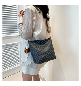 Detail of crossbody tote bag with geometric pattern and striped shoulder strap