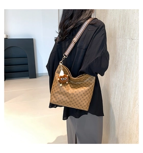 Detail of hobo tote bag featuring retro diamond pattern and striped shoulder strap