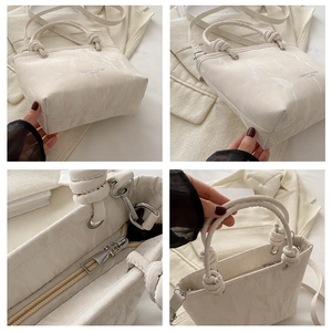 Detailed view of marble pattern leather bucket bag with knotted handle and silver hardware