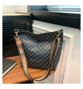 Detail of printed crossbody bag with adjustable striped wide canvas shoulder strap