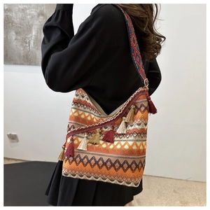 Detail van bohemien hobo tas met geometrisch borduurwerk en kleurrijke kwastjes