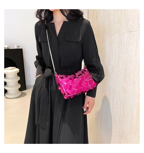 Detail of rose pink sequin crossbody bag with silver chain strap on black dress