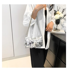 Close-up of sparkling silver sequin texture and chain strap on a stylish handbag