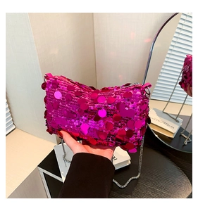 Macro detail of rose red sequin crossbody bag with reflective metallic chain strap