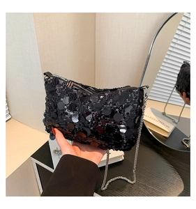 Detailed macro view of large black sequins and silver chain strap on a mini square bag