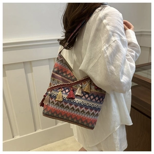 Detail van bohemien gebreide shopper met geometrische patronen en gekleurde kwastjes