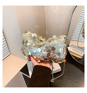 Close-up of sparkling large metal sequins and metallic chain on a stylish shoulder bag