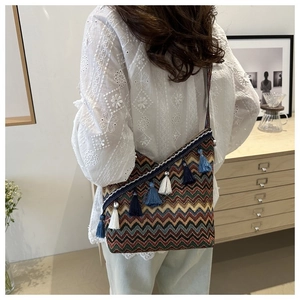 Detail van boheemse jacquard tas met kleurrijke golfpatronen en franje kwastjes