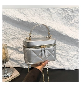 Detail of silver quilted bucket bag with gold chain strap and metallic finish