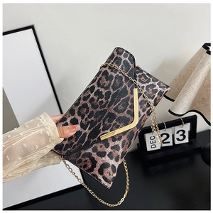 Detailed close-up of leopard print envelope clutch with V-shaped gold clasp and chain strap