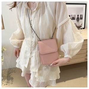 Pink minimalist crossbody phone bag with chain strap styled with a white shirt outfit
