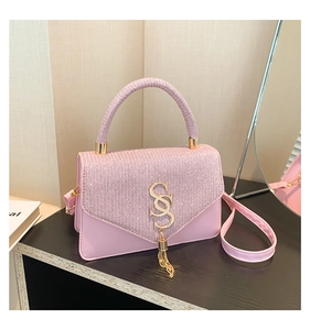 Close-up of pink rhinestone handbag with gold S-logo hardware and tassel detail