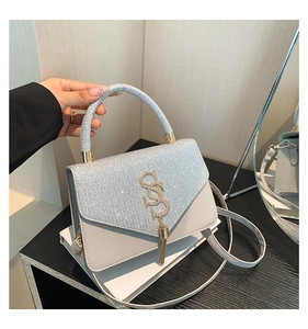 Detail of light grey shoulder bag with sparkling silver glitter and gold SS logo