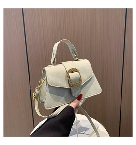 Detailed view of a light sage green trapezoid handbag with matte finish and metal buckle