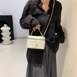 Chic beige quilted chain crossbody bag with gold hardware shown on a model