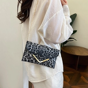 Fashionable leopard print envelope clutch with gold V-detail and slender chain strap