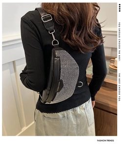 Détail de vue arrière d'un sac bandoulière en cuir noir orné de strass argentés brillants