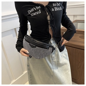 Détail du sac bandoulière noir avec strass brillants et écusson de logo de mode
