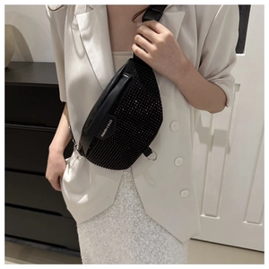 Détail d'un sac bandoulière noir orné de strass avec étiquette mode et anneau en métal