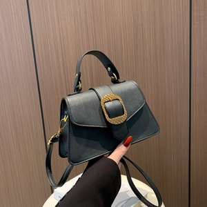 Vintage black leather crossbody bag with oversized gold buckle and top handle detail