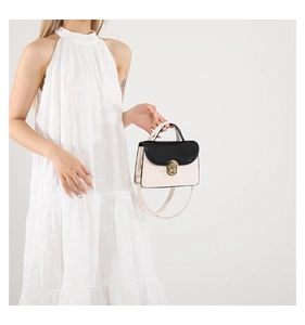 Detail of minimalist black and white crossbody bag with elegant metal twist lock