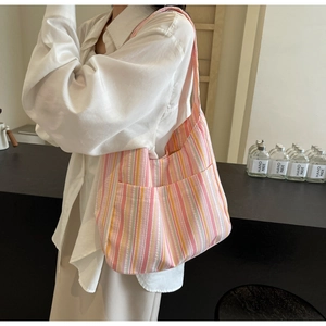 Detail of pink and orange striped tote bag showing front pockets and canvas texture