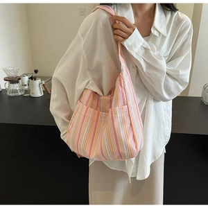 Detail view of large canvas tote bag with vibrant pink and orange vertical stripes