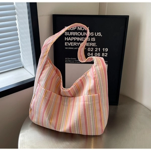 Detail of colorful striped canvas tote bag showing textured seersucker fabric and dual pockets