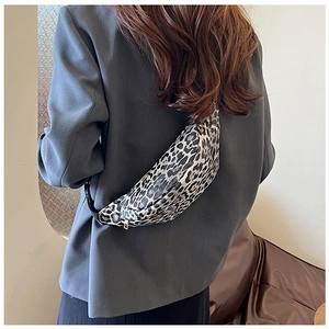 Detailed view of stylish leopard print crossbody bag worn by model over a grey blazer