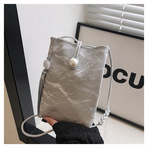 Detail of silver crossbody phone bag featuring wrinkled texture and large pearl button