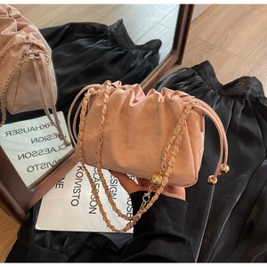 Pink pleated cloud bag with a gold chain strap and drawstring metallic sphere details