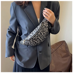 Detail der Umhängetasche mit Leopardenmuster und Goldzipper am grauen Blazer getragen