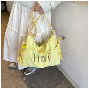 Close-up of pale yellow high-capacity nylon bag featuring the Hai letter print