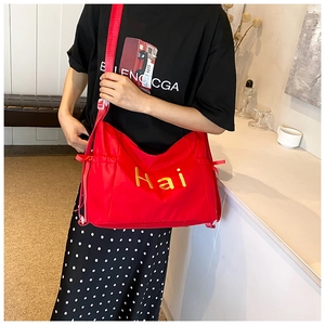Red large nylon crossbody bag featuring yellow 'Hai' embroidery and side drawstring pockets