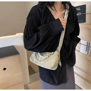 Détail du sac nuage plissé avec chaîne de perles élégante et finition texturée fine