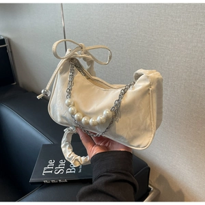 Détail du sac croissant blanc cassé avec chaîne en perles et poignée plissée
