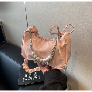 Détail du sac rose montrant la chaîne argentée et les ornements en grosses perles