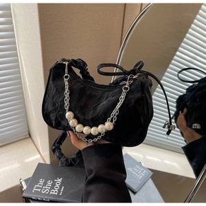 Détail du sac à main plissé noir avec bandoulière en perles et chaînes argentées élégantes