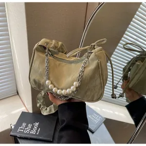 Détail du sac à bandoulière plissé beige clair avec perles blanches et chaîne argent
