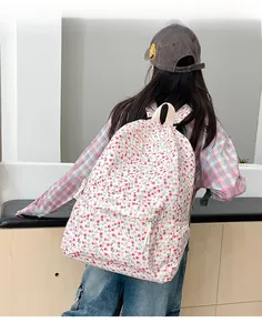 Floral canvas backpack detail featuring red flower patterns and front zipper pocket design