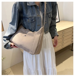 Détail du sac cabas en toile beige avec boucle magnétique en métal et poche texturée