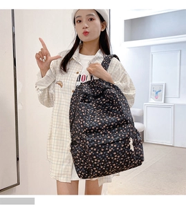 Detailed view of black floral backpack with tulip patterns on an Asian model back