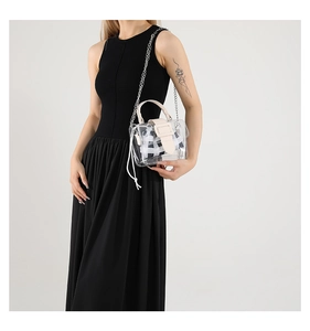 Detailopname van transparante PVC-tas met contrasterend leer en geruite binnentas