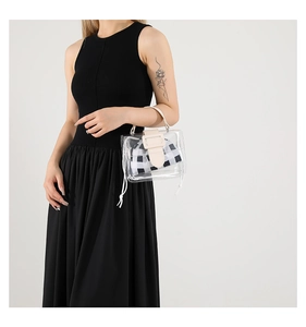 Detail van transparante PVC handtas met geruite binnenkant en lederen handvat