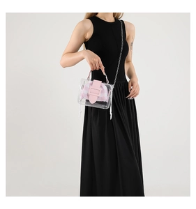 Detail van transparante PVC-tas met roze geruite binnentas en zilverkleurige ketting